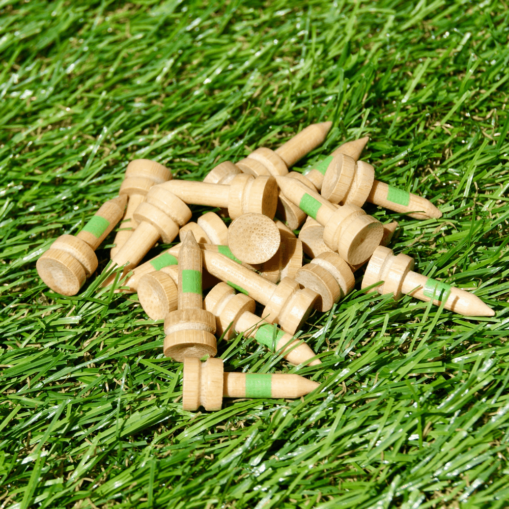 pile of loose green bamboo golf tees on astro turf