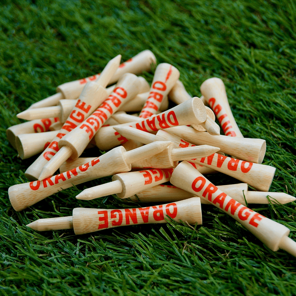 pile of orange bamboo tees on astro grass